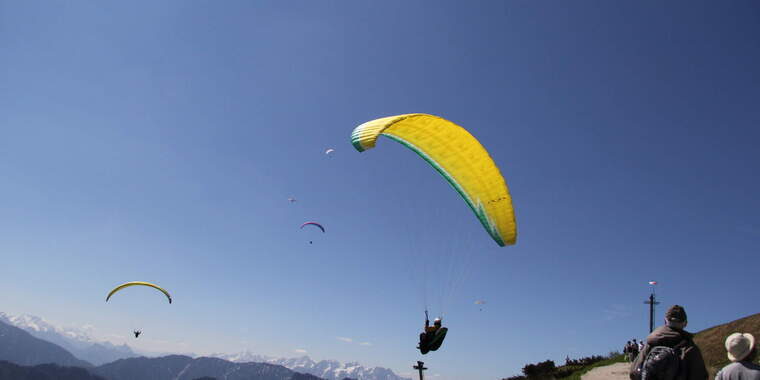 Zwei Paraglider fliegen durch die Luft mit blauem Himmel im Hintergrund